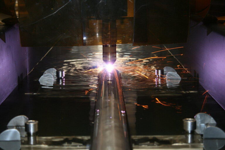 Pipe being cut by a plasma torch in a pipe cutting water channel